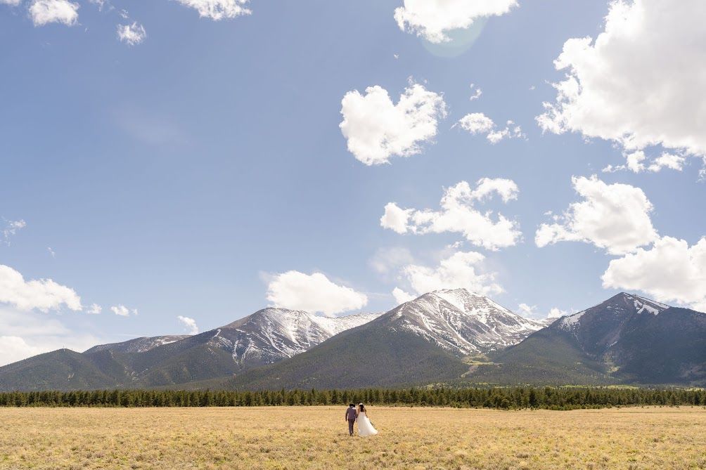 Couple standing alone in a wide Colorado mountain valley on their wedding day