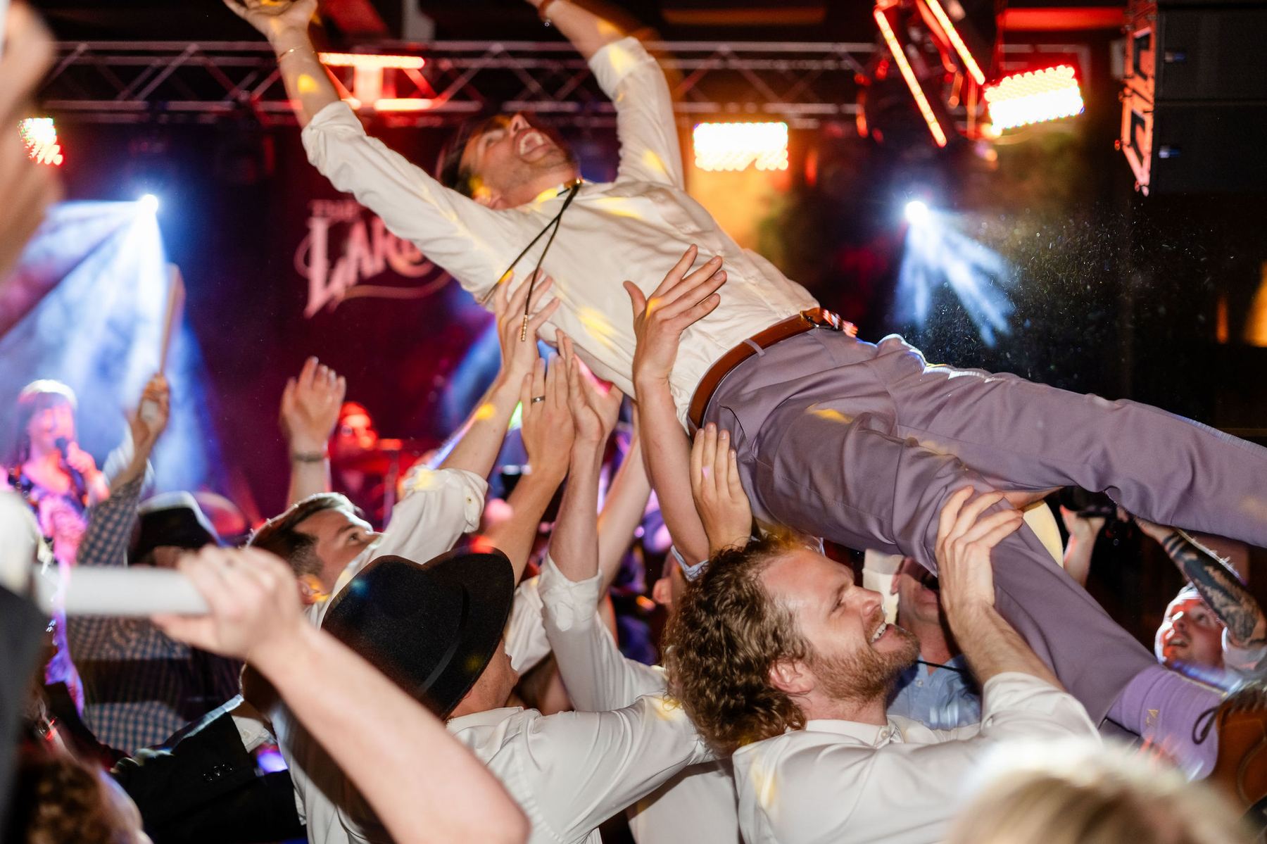 Groom crowd surfing at a Colorado wedding reception